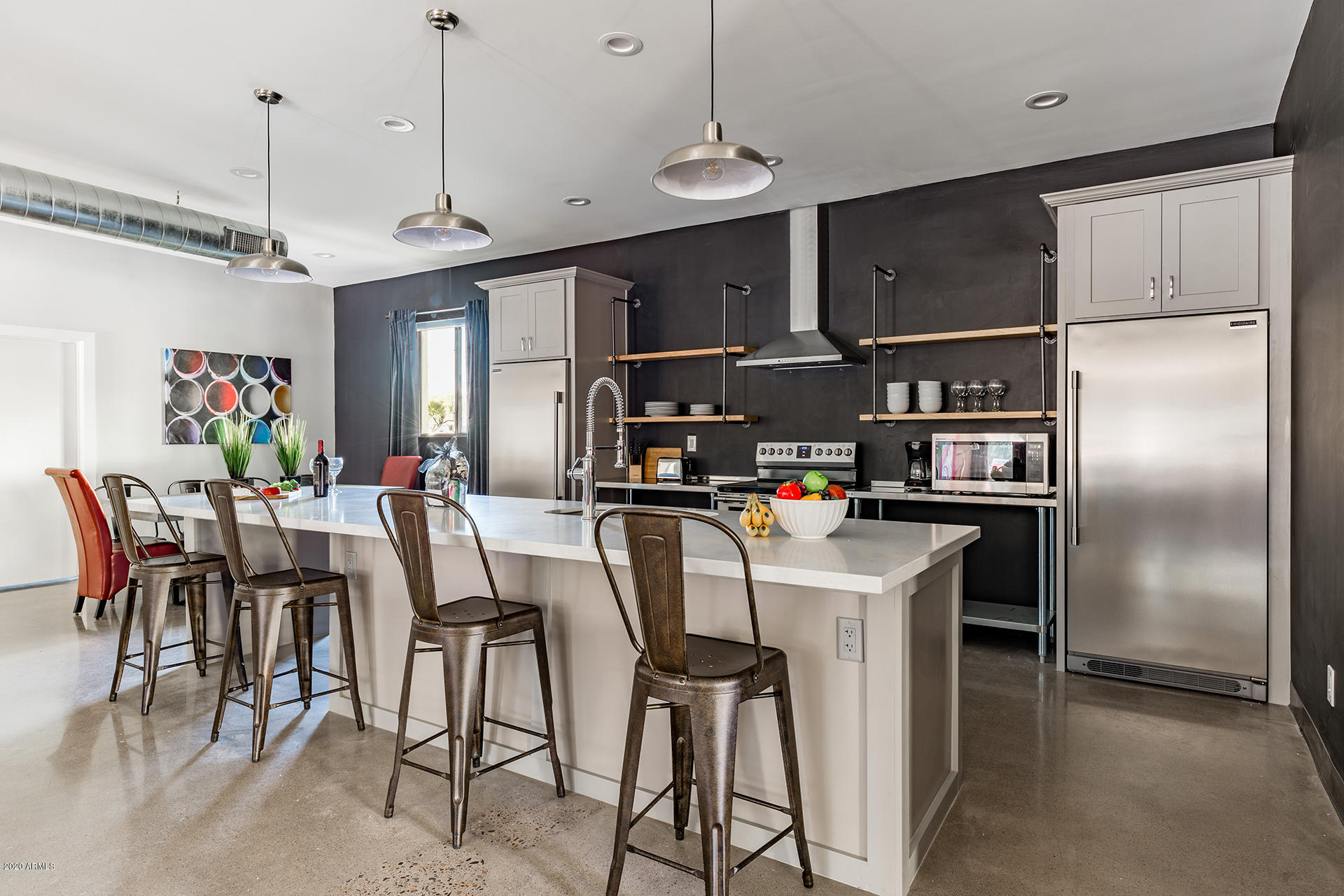 7505 East Main Street, Unit A Scottsdale, AZ 85251 - Photo 10 of 30 a kitchen with stainless steel appliances granite countertop a dining table chairs and refrigerator