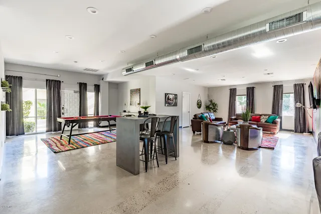 a kitchen with a dining table chairs and refrigerator