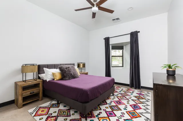 a bathroom with a toilet sink vanity granite and shower