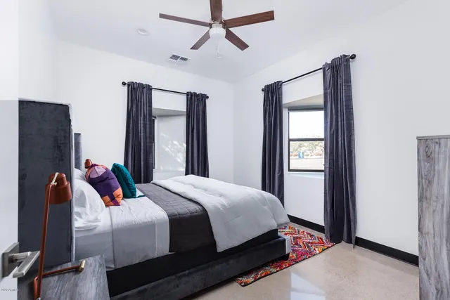 a bedroom with a bed and wooden floor