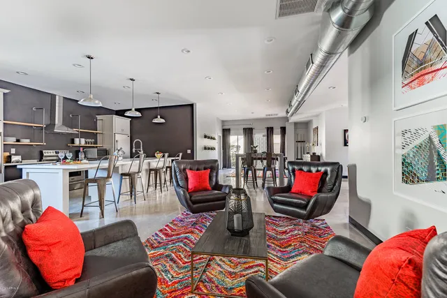 a living room with furniture kitchen and a wooden floor