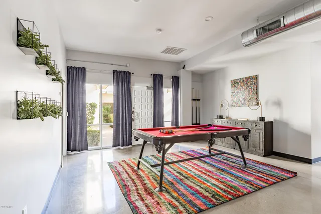 a living room with a rug a table and a potted plant