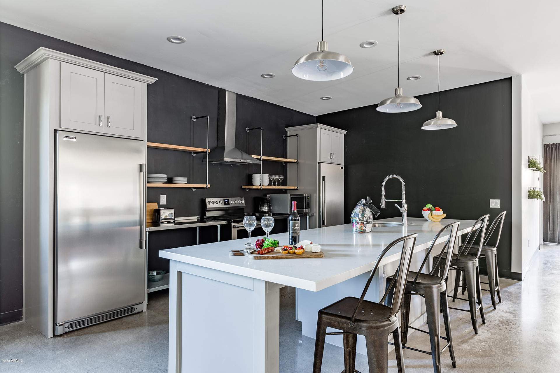 7505 East Main Street, Unit A Scottsdale, AZ 85251 - Photo 9 of 30 a kitchen with stainless steel appliances granite countertop a dining table chairs refrigerator and cabinets