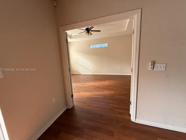 a view of empty room with wooden floor