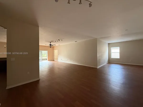 a view of a livingroom with wooden floor and a window