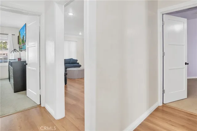 a view of a hallway with wooden floor and closet