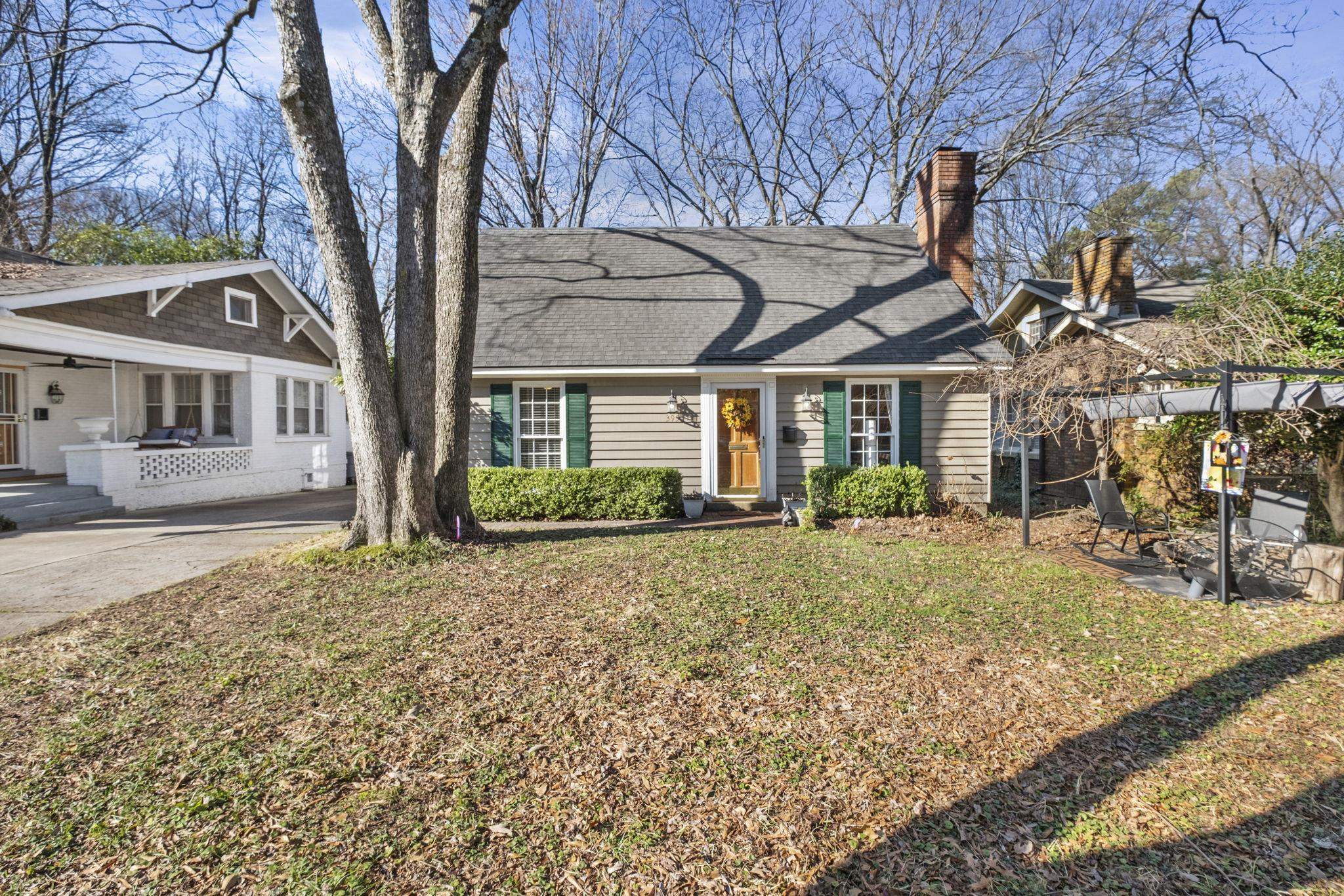 a view of a house with a tree in front of it
