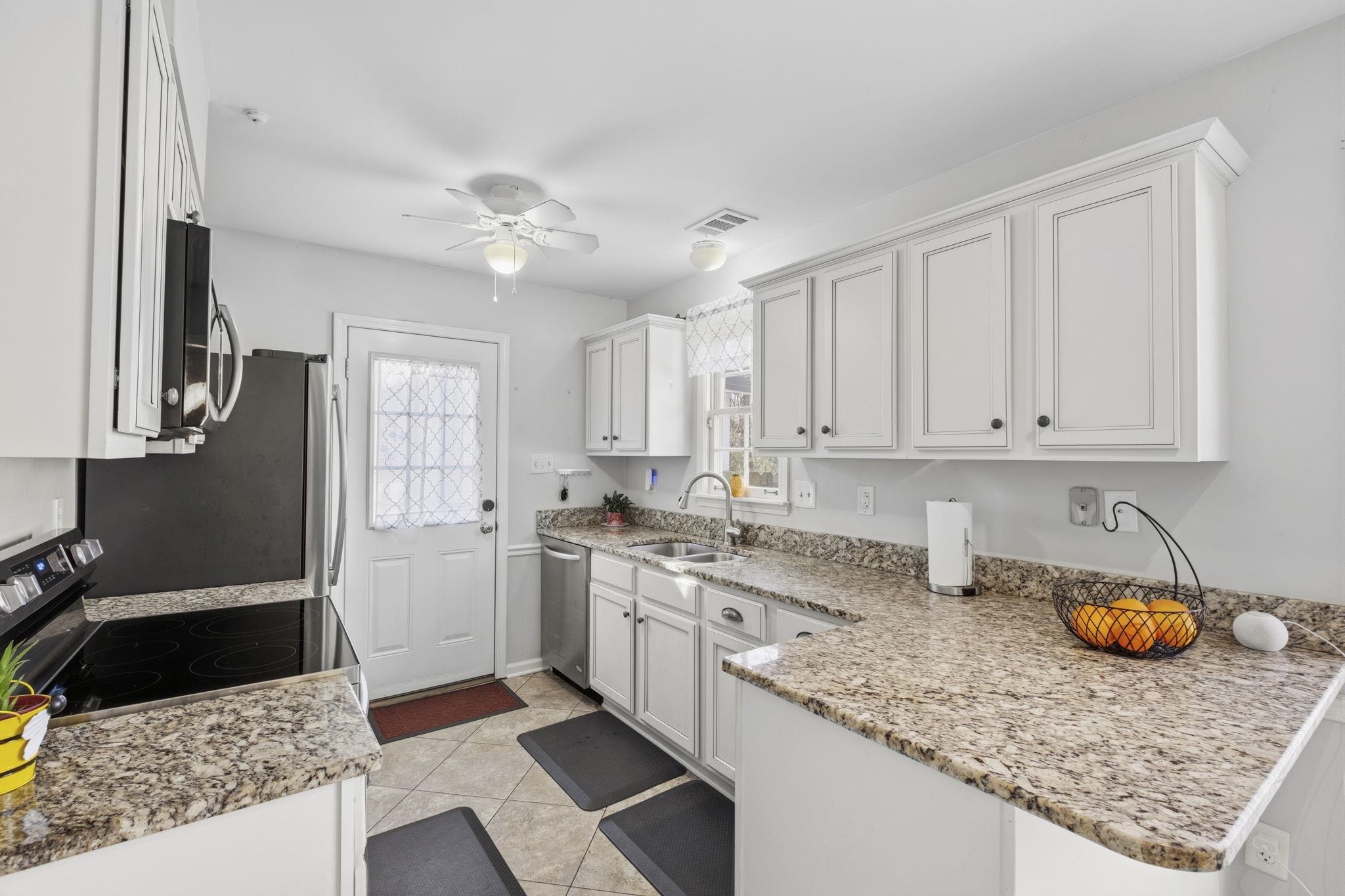 395 Alexander Street Memphis, TN 38111 - Photo 13 of 36 a kitchen with stainless steel appliances granite countertop a sink stove refrigerator and cabinets