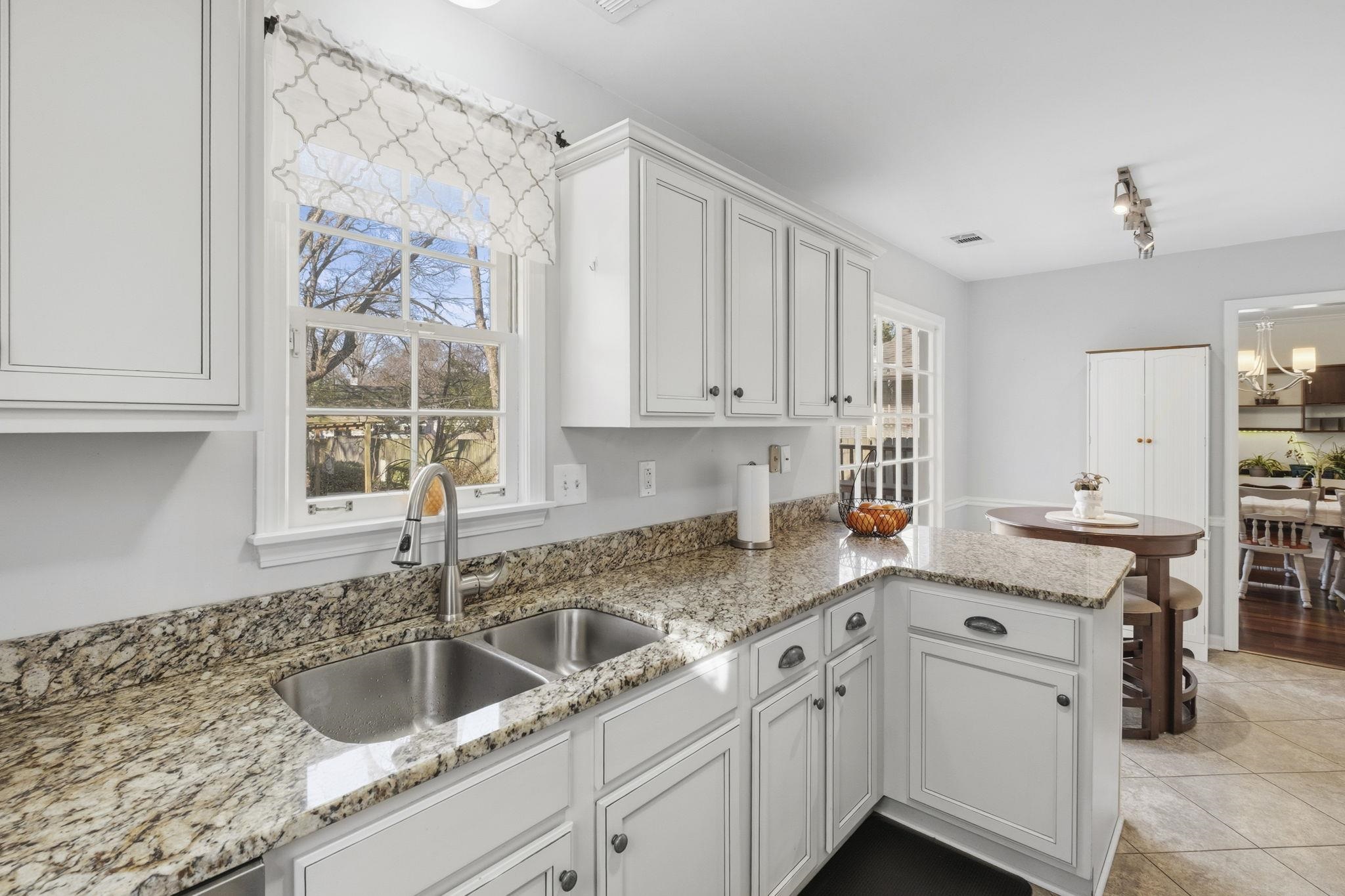 395 Alexander Street Memphis, TN 38111 - Photo 16 of 36 a kitchen with granite countertop a sink a window and cabinets