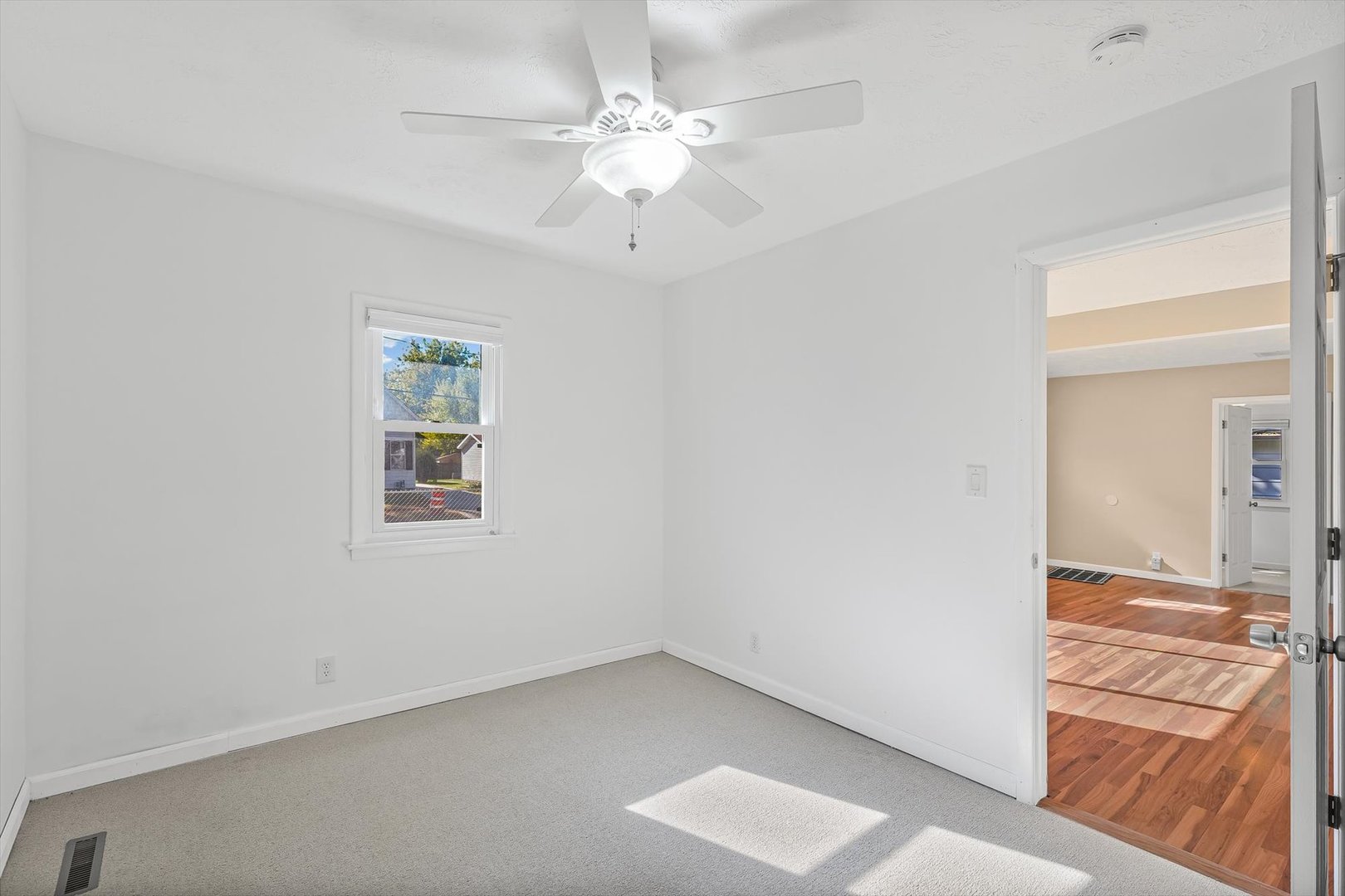 606 Cullom Street Normal, IL 61761 - Photo 15 of 27 an empty room with a chandelier fan and windows