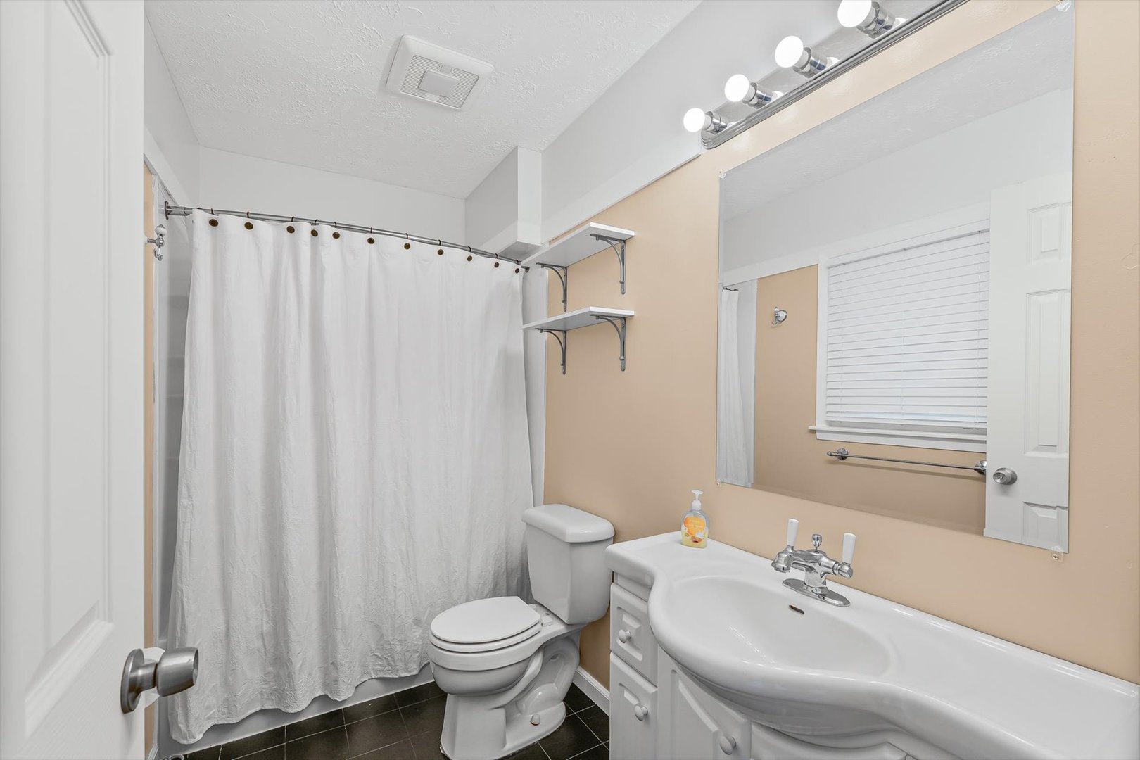 606 Cullom Street Normal, IL 61761 - Photo 20 of 27 a bathroom with a sink toilet a mirror and shower curtain