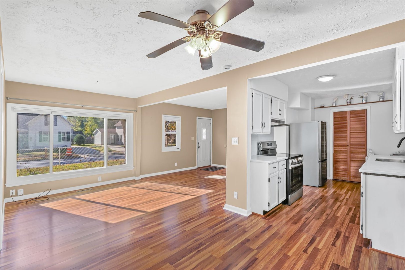 606 Cullom Street Normal, IL 61761 - Photo 9 of 27 a view of a kitchen with a stove cabinets a ceiling fan and wooden floor
