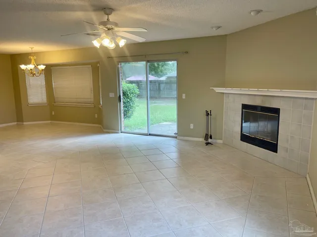 a view of empty room with a fireplace and fan
