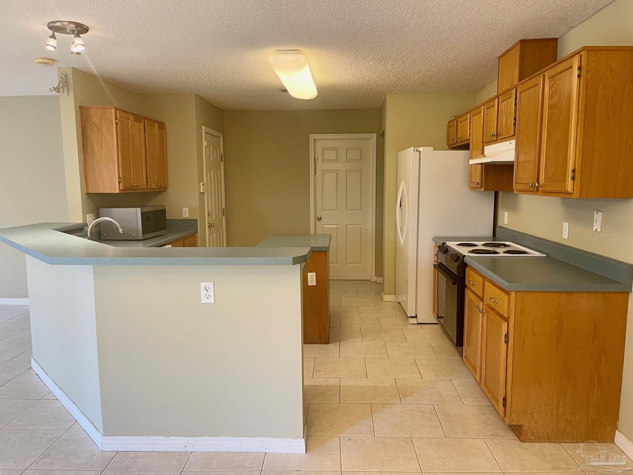 5162 Goshawk Drive Milton, FL 32570 - Photo 6 of 26 a kitchen with stainless steel appliances granite countertop a sink a stove a refrigerator a washer dryer and a refrigerator
