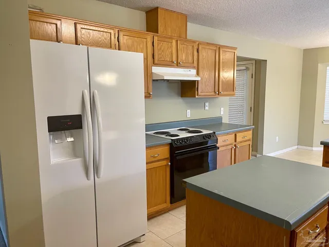 a kitchen with stainless steel appliances granite countertop a refrigerator and a stove