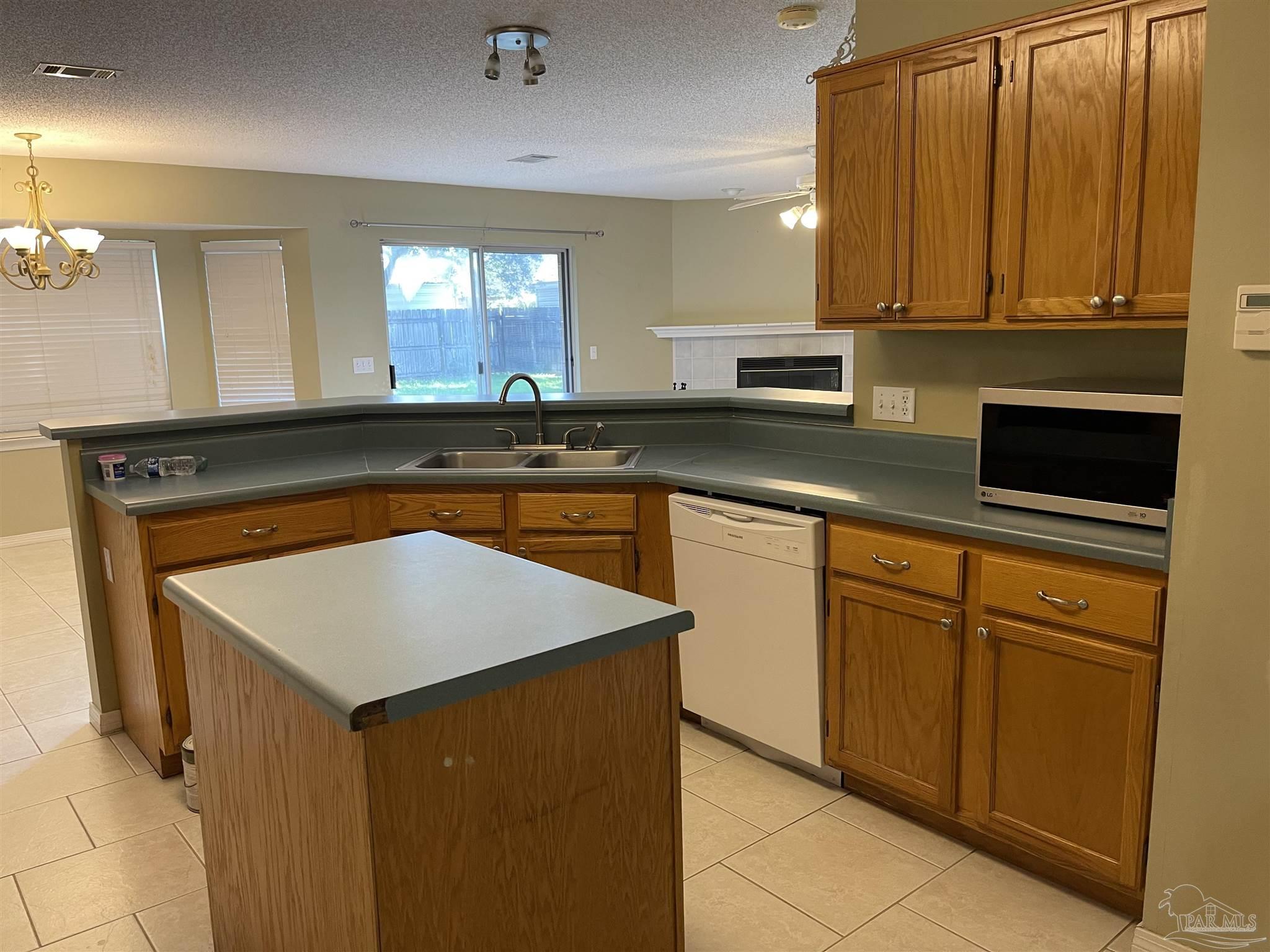 5162 Goshawk Drive Milton, FL 32570 - Photo 9 of 26 a kitchen with stainless steel appliances granite countertop a sink and a microwave