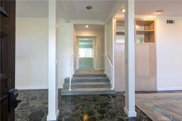 a view of a hallway with wooden floor and staircase