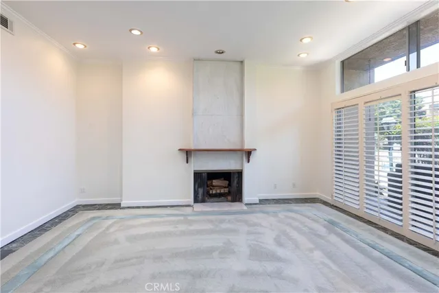 an empty room with windows and a fireplace