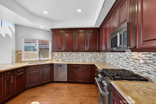 an open kitchen with stainless steel appliances granite countertop a refrigerator and a stove top oven