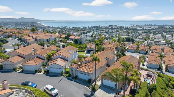 an aerial view of residential houses with outdoor space and parking