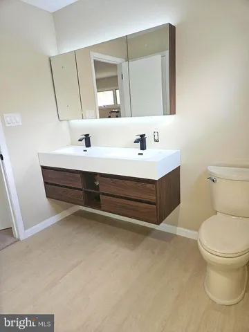 a bathroom with a sink toilet vanity and mirror
