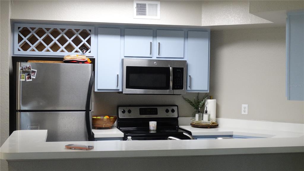 7240 Westpointe Boulevard, Unit 1125 Orlando, FL 32835 - Photo 13 of 33 a kitchen with a stove and a microwave