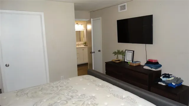 a bedroom with a bed and a flat screen tv