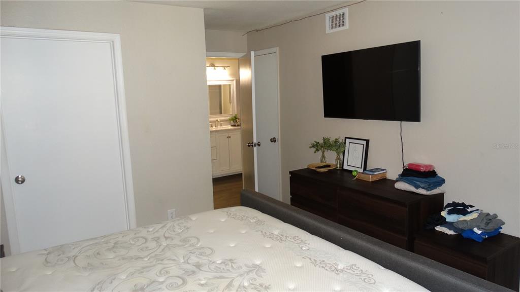 7240 Westpointe Boulevard, Unit 1125 Orlando, FL 32835 - Photo 7 of 33 a bedroom with a bed and a flat screen tv
