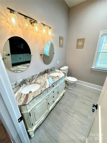 a bathroom with a double vanity sink mirror and toilet