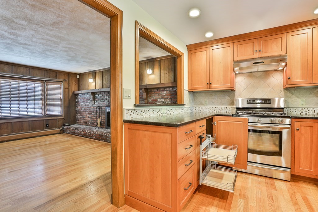 9 Handel Road Billerica, MA 01821 - Photo 21 of 40 a kitchen with granite countertop a stove a sink and a microwave