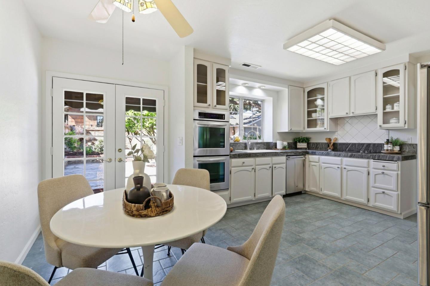 20360 Orchard Road Saratoga, CA 95070 - Photo 16 of 43 a kitchen with stainless steel appliances granite countertop a kitchen island a stove a table and chairs
