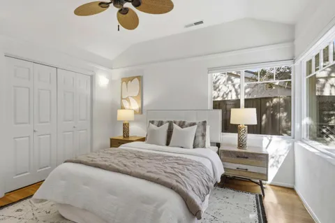 a bedroom with a bed table and a potted plant