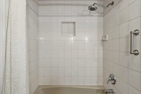 a view of a house with a small yard plants and large tree