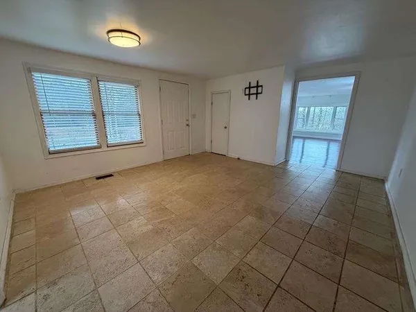 a view of an empty room with wooden floor and a fireplace