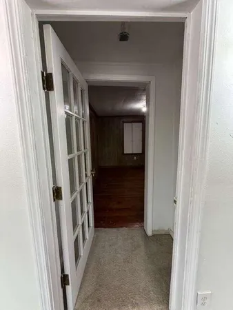 a view of an empty room with a chandelier fan
