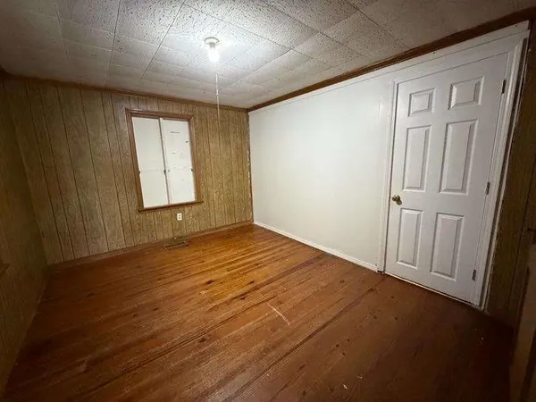 an empty room with a fan & a window