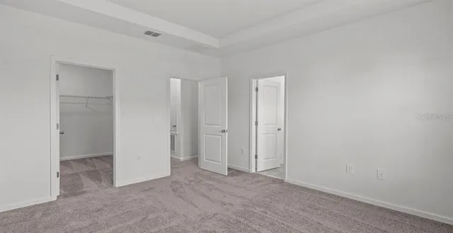 a view of room with walk in closet and wooden floor
