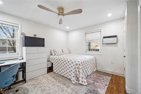 a bedroom with a bed and a flat tv screen on a dresser