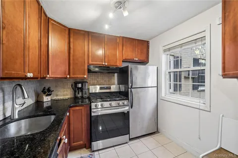 a kitchen with granite countertop a stove a sink and a refrigerator