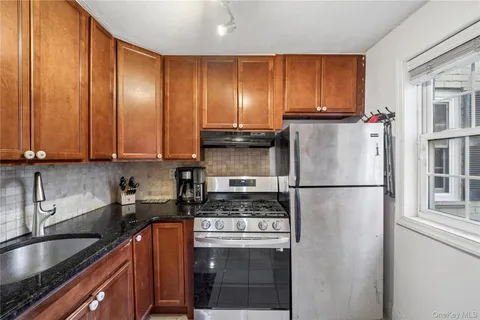 a kitchen with a refrigerator sink and cabinets