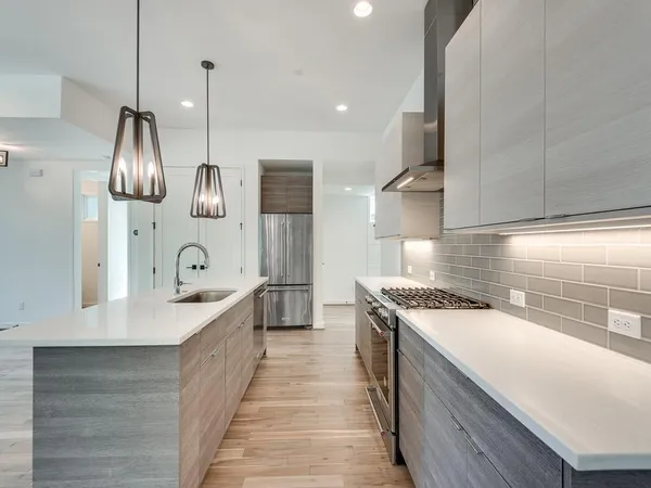 a kitchen with stainless steel appliances a sink stove and cabinets