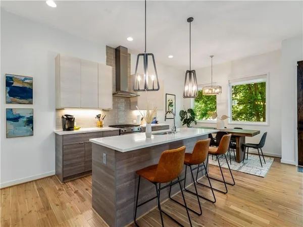 a kitchen with stainless steel appliances granite countertop a sink a stove and chairs