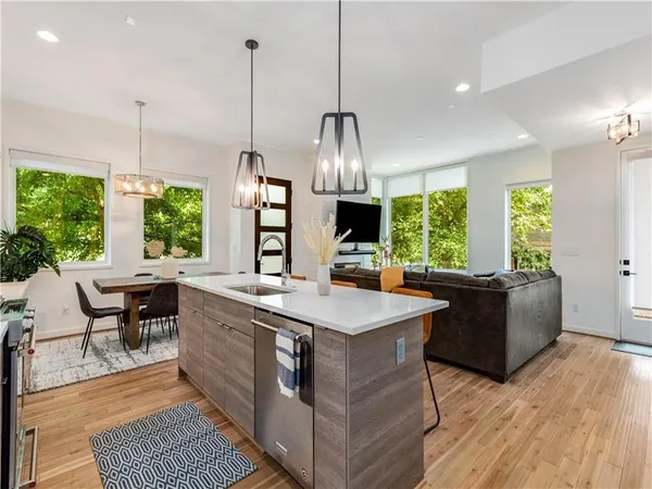a kitchen with kitchen island a large counter top space a sink a window and living room view