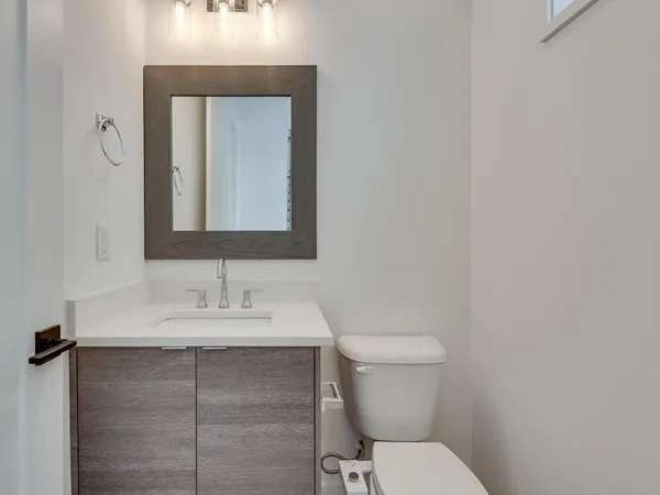 a bathroom with a toilet sink and mirror