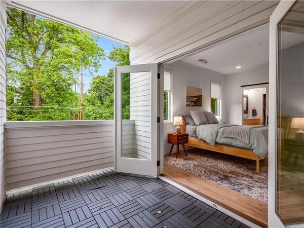 a bedroom with a bed and large windows