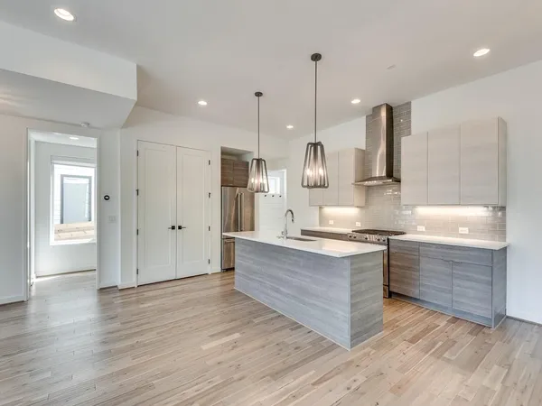 a large kitchen with granite countertop a large counter top a sink stainless steel appliances and cabinets