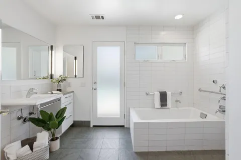 a bathroom with a sink a bathtub and a mirror