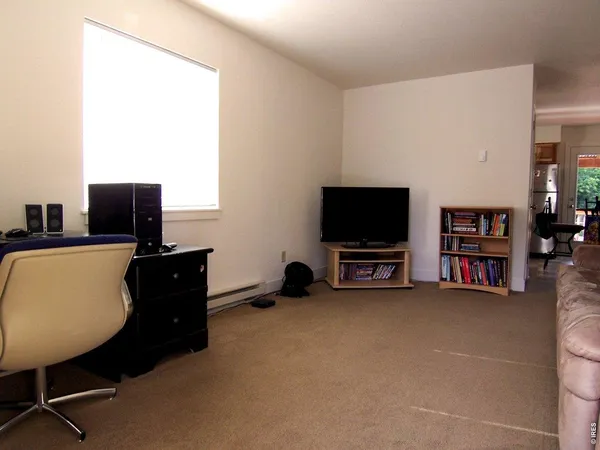 a view of a room with gym equipment and wooden floor