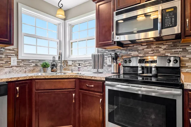 a kitchen with stainless steel appliances granite countertop a stove microwave and sink