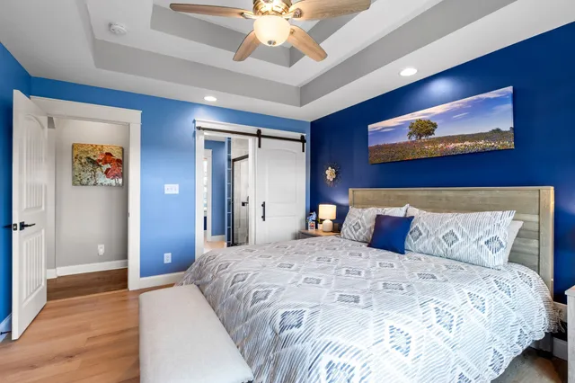 a bedroom with a large bed and a chandelier